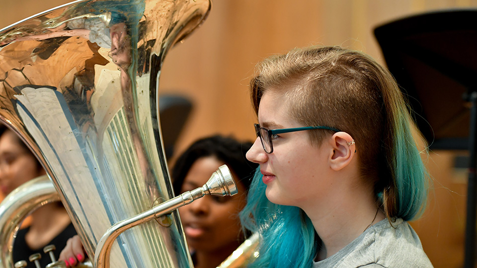 RCMJD student with tuba in rehearsal
